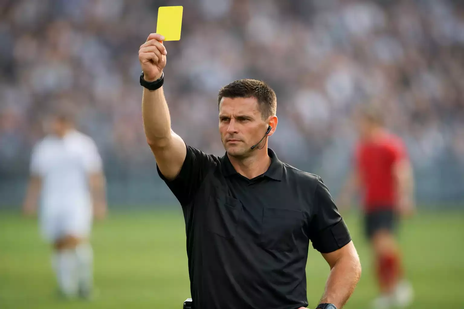 Árbitro de fútbol mostrando una tarjeta durante un partido