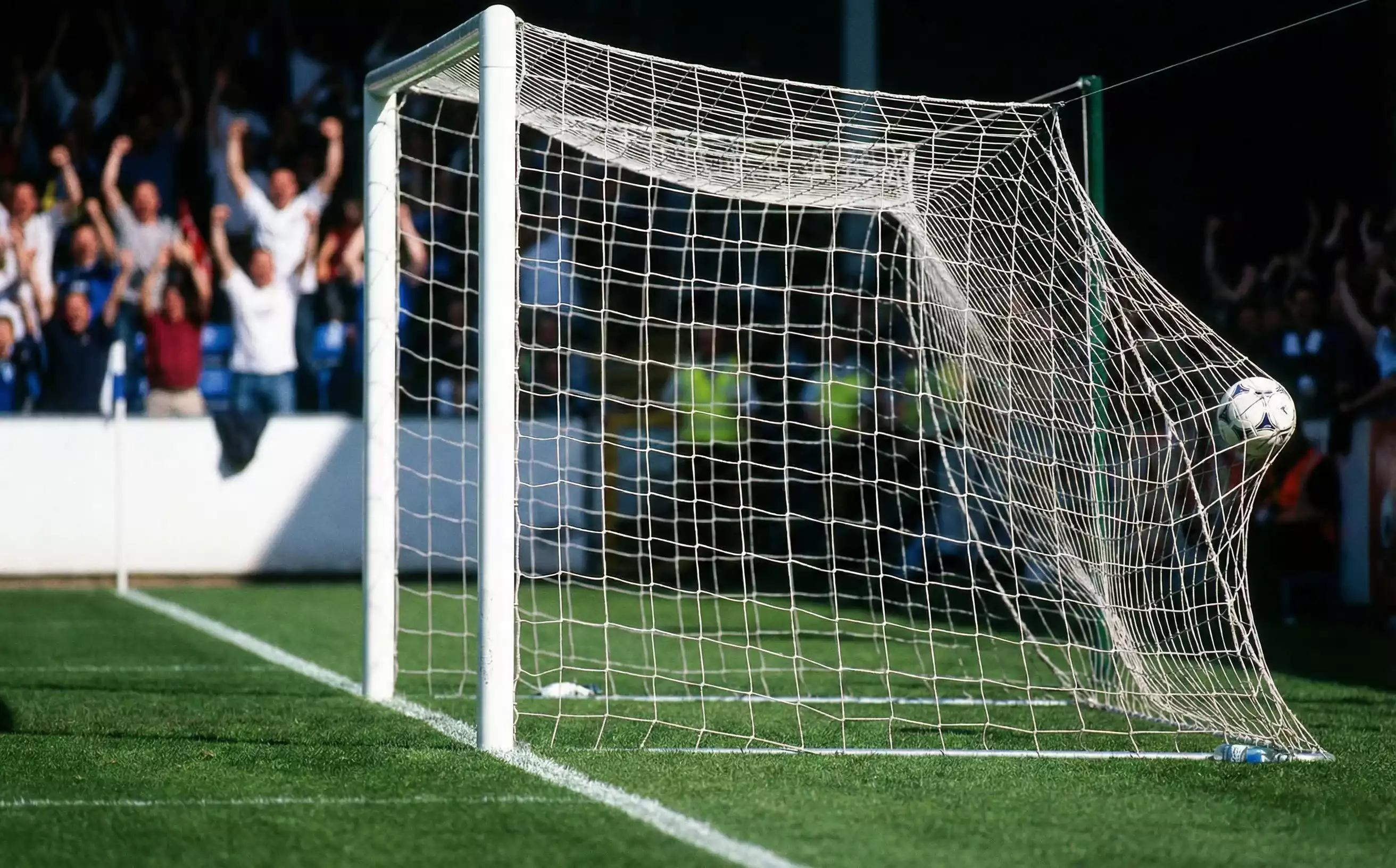 Balón de fútbol entrando en la portería durante un gol
